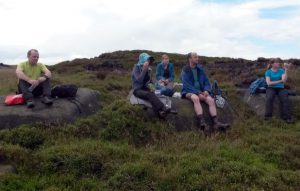 Group of walkers stopping on a hillside for a rest.