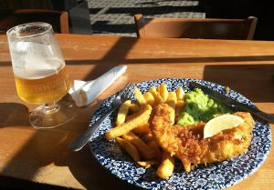 A plate with Fish and Chips and a pint of San Miguel.