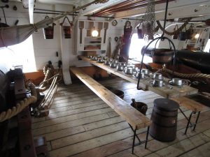Inside the gun bay of an old warship with tables set for lunch