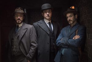 Three characters from Ripper street standing in a dark alley.