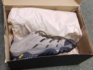 Some brand new Merrell trainers in a box just opened.
